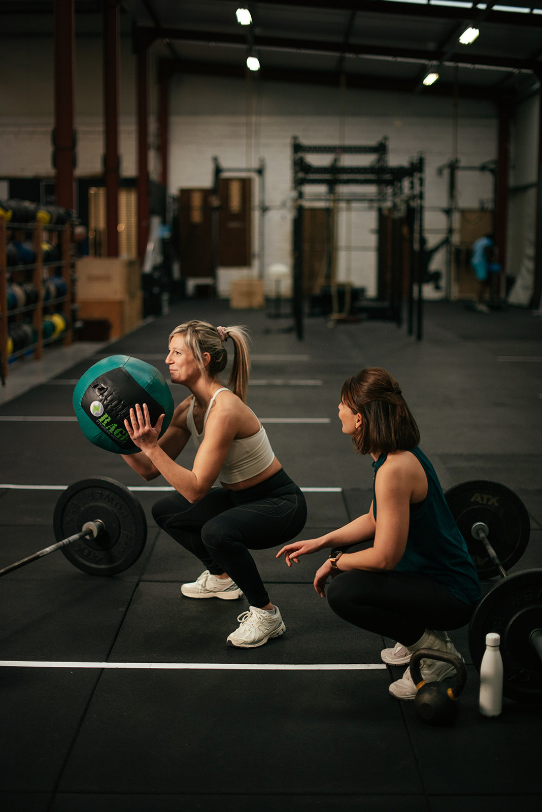 Liselotte begeleidt een vrouw bij krachttraining met medicine ball