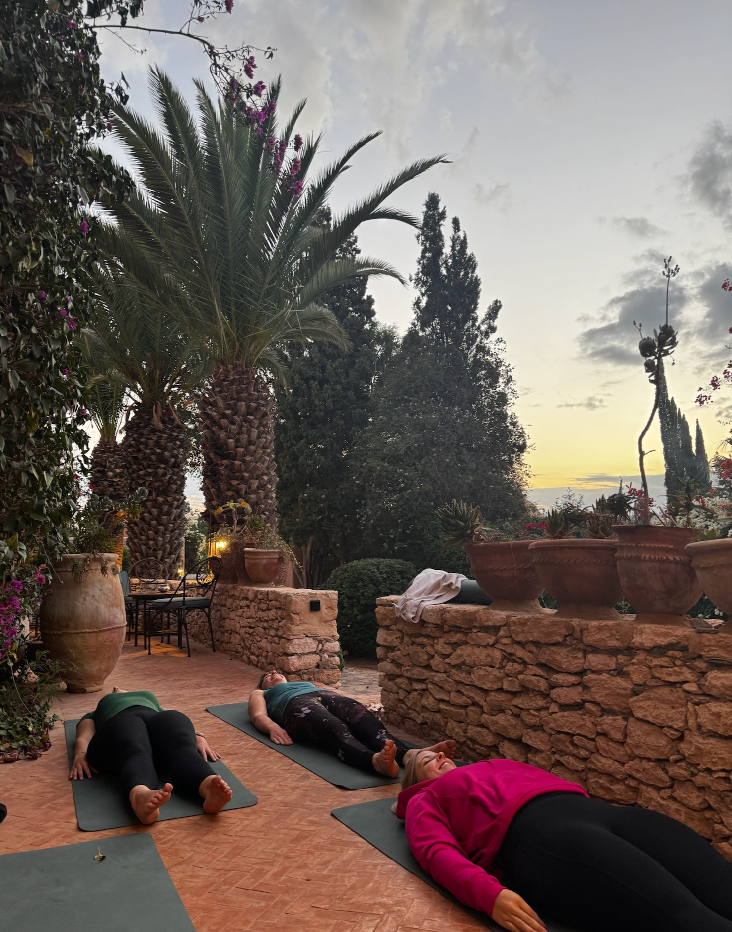 Yoga in de tuin bij zonsondergang